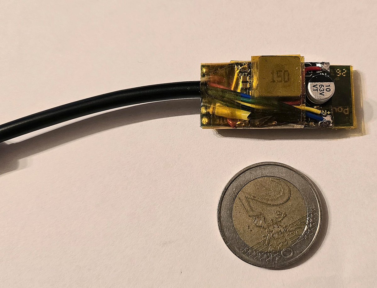 The finished converter wrapped in Kapton tape, next to a 2 euro coin for size